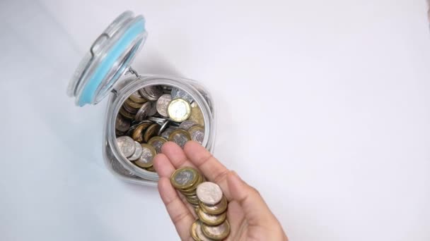 Bovenaanzicht van de mens hand besparende munten in een pot — Stockvideo