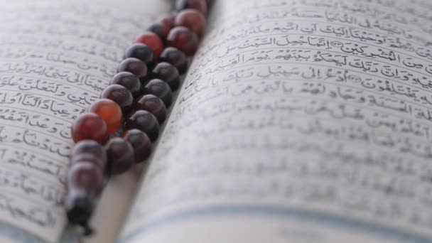 圣书《古兰经》和念珠放在桌上，关门. — 图库视频影像