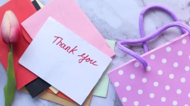 Kağıt üzerinde teşekkür mesajı, arkaplanda lale çiçeği. 