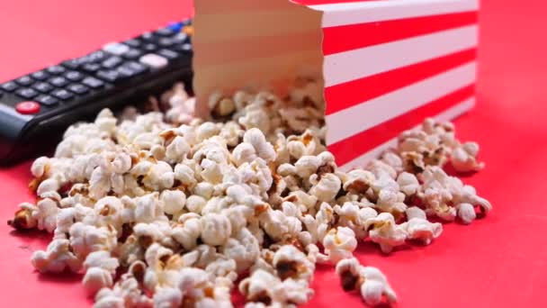 Zblízka popcorn a dálkové televize na červeném pozadí — Stock video