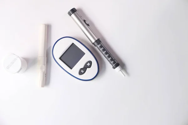 Диабетические измерительные инструменты и инсулиновая ручка на столе — стоковое фото