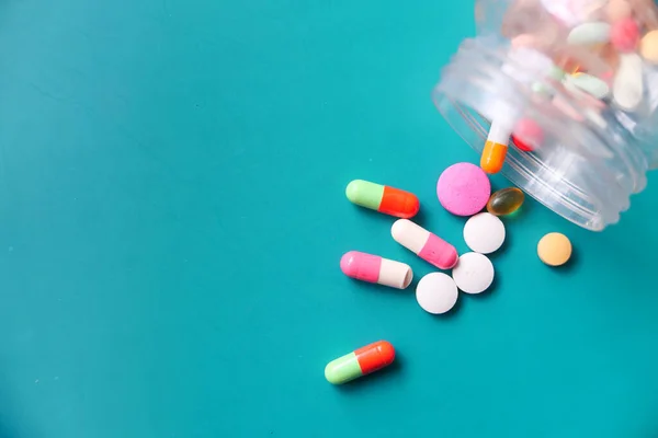 Ovanifrån av färgglada piller spiller på grön bakgrund — Stockfoto