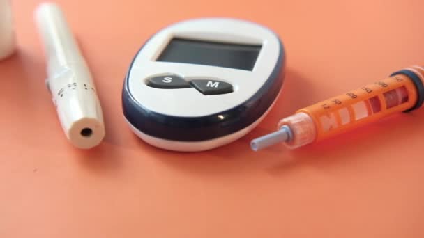 Strumenti di misura per diabetici e penna per insulina su sfondo arancione — Video Stock