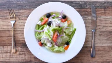 Masadaki kasede Yunan salatasının en üst görüntüsü.