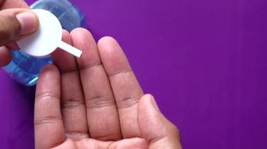 Virüsü önlemek için dezenfektan jel kullanarak genç adamın elini kapat. 