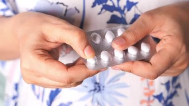 Kadınların elleri su toplayan bir paketten ilaç alırken. 