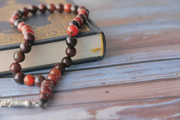 Buku suci Quran dan rosario di atas meja, tutup. — Stok Foto