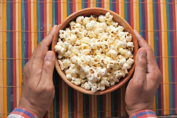 Palomitas de maíz en un tazón en un escritorio de madera — Foto de Stock