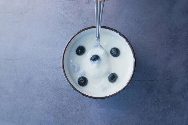 Perto de iogurte fresco com baga azul em uma tigela — Fotografia de Stock