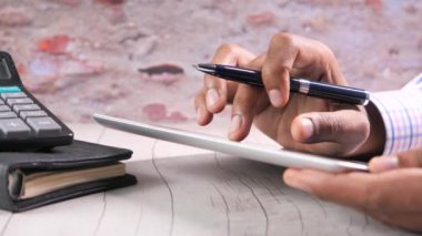 Ofis masasında dijital tablet üzerinde çalışan adam eli. 