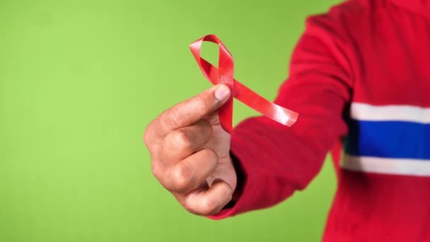 Main tenant un ruban rouge anti-VIH contre un écran vert — Video