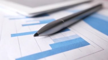 finansal grafik, hesap makinesi ve not defteri masanın üzerinde 