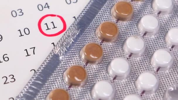 Tabletki antykoncepcyjne, kalendarz i notatnik na stole — Wideo stockowe
