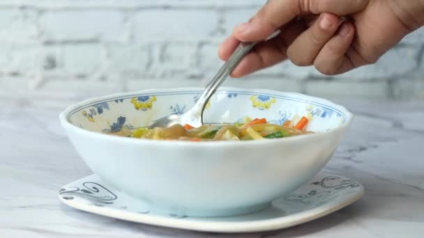 Close up of young man eating vegetable soup — Stock Video