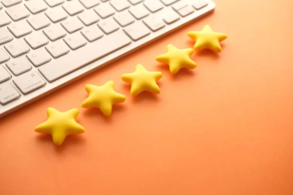 Kundenbewertungskonzept. Bewertung goldener Sterne auf orangefarbenem Hintergrund — Stockfoto