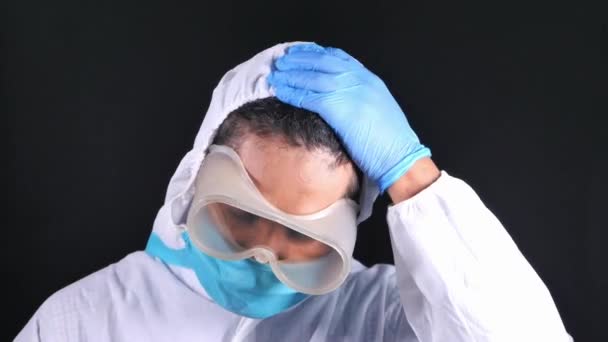 Dokter pria yang menyedihkan memakai PPE terisolasi pada hitam — Stok Video