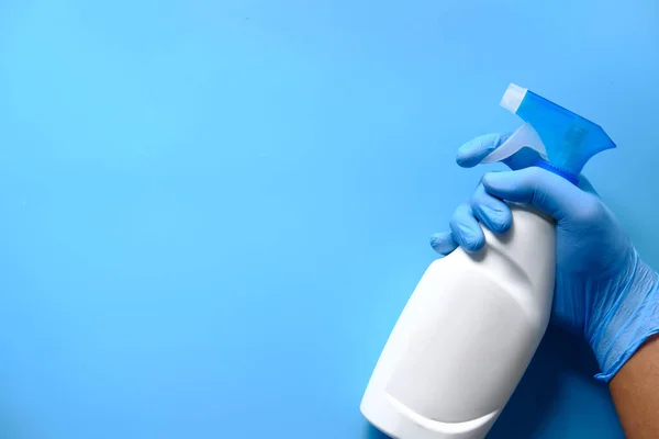 Mano en guantes de goma azul que sostiene la botella del aerosol con espacio de copia —  Fotos de Stock