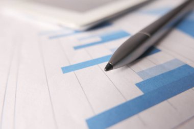 finansal grafik, dijital tablet ve kalem masanın üzerinde 