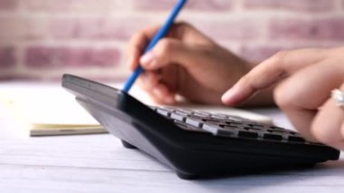 Kadınlar ofis masasında hesap makinesi kullanıyorlar. 