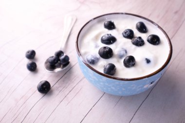 Bir kasede mavi böğürtlenli taze yoğurt. 
