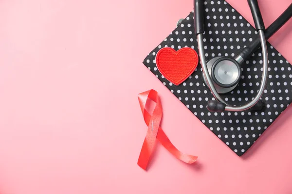 Red ribbon HIV, and stethoscope on pink background. — Stock Photo, Image