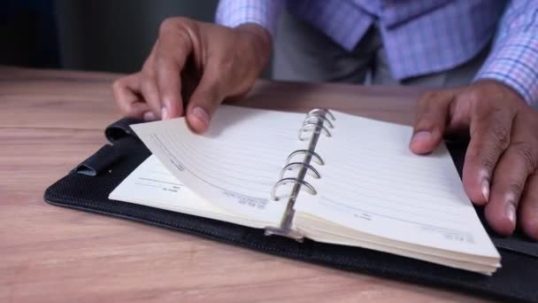 Feche-se de mão de homem que vira um pager de um diário — Vídeo de Stock