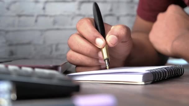 Close-up van de man hand schrijven op notitieblok. — Stockvideo