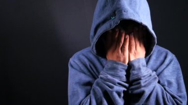 Kapüşonlu üzgün adam ellerinin fotokopi aletiyle kaplanmış. 