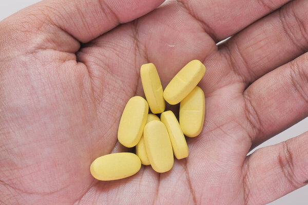 Close up of man hand taking medicine 