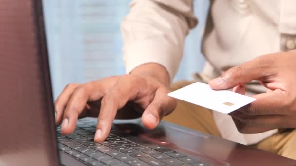 Niet herkende man handen houden van credit card en met behulp van laptop winkelen online — Stockvideo