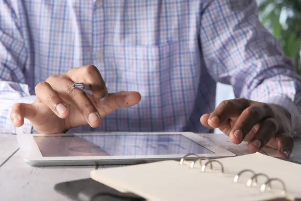 Man hand working on digital tablet at office desk, using self created chart — стоковое фото