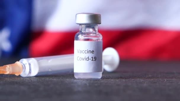 Close up of coronavirus vaccine and syringe o american american flag — Stock Video