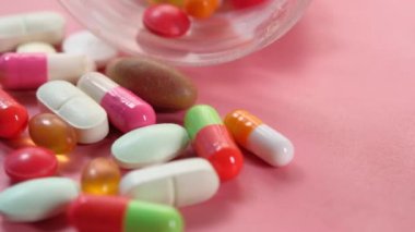 Pembe arka plana dökülen renkli hapları kapat. 