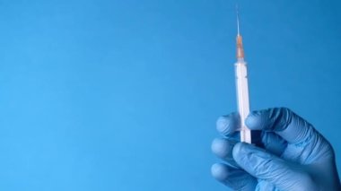 Doktor elinde şırınga tutan tıbbi eldivenler getirdi..