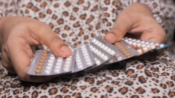 Vrouwen hand golding anticonceptie pillen close-up — Stockvideo
