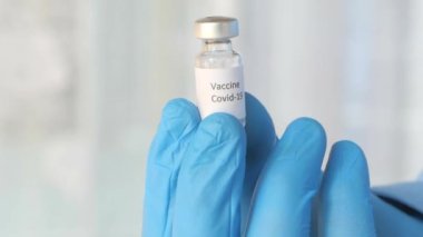 Doktor elinde koronavirüs aşısı olan eldivenleri teslim et.
