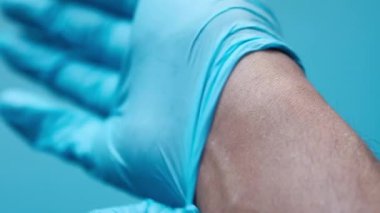 Doktor tıbbi eldiven takıyor, yakın çekim.