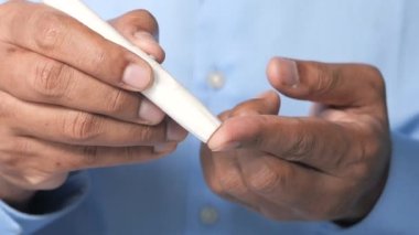 Erkekler evlerinde glikoz seviyesini ölçer. 