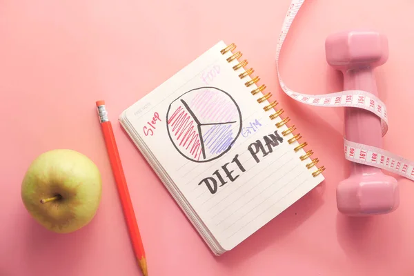 Diet plan with almond nut, dumbbells, apple on table — Stock Photo, Image
