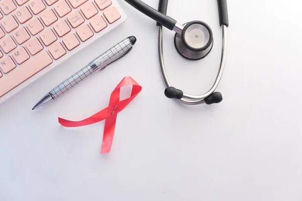 Red ribbon HIV, and stethoscope on white background. — Stock Photo, Image