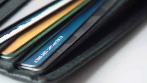 Close-up van creditcards in een portemonnee op houten achtergrond — Stockvideo