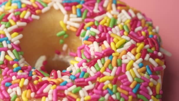 Nahaufnahme von frisch gebackenen Donuts auf rosa — Stockvideo