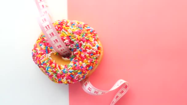 Nahaufnahme von Donuts und Maßband auf rosa Hintergrund. — Stockvideo