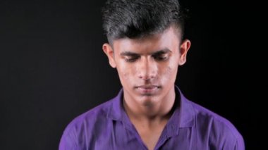 Genç Asyalı adam gülümsüyor ve siyah kameraya bakıyor..