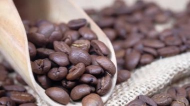 Taze kahve çekirdekleri ve tahta arka planda kaşık. 