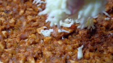 Kadınlar pizzaya mozzarella peyniri ekler.