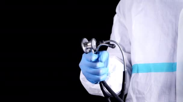 Mano del médico en guantes protectores que sostienen estetoscopio aislado en negro — Vídeo de stock