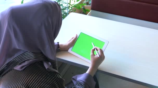 Vista trasera de las mujeres musulmanas con pañuelo en la cabeza utilizando tableta digital interior. — Vídeo de stock