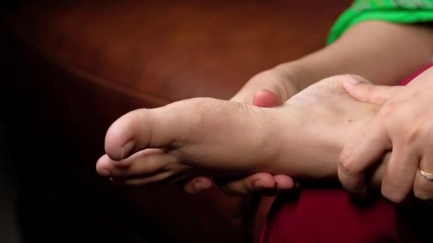 ปิดเท้าผู้หญิง และนวดมือที่จุดบาดเจ็บ . — วีดีโอสต็อก