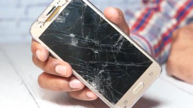 Kırık akıllı telefonu tutan adama yakın dur..